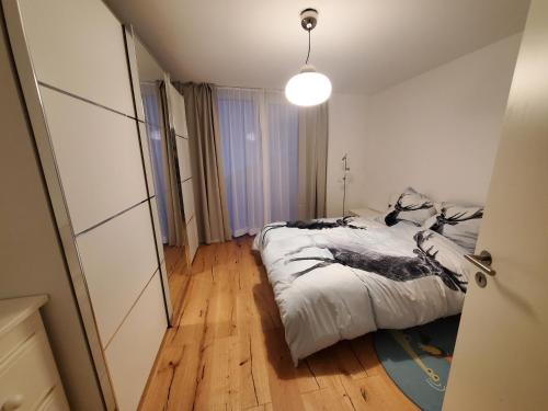 małą sypialnię z łóżkiem i lampką w obiekcie Panorama * w mieście Obstalden