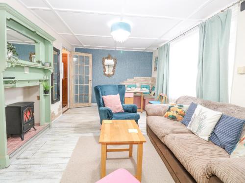 a living room with a couch and chairs and a fireplace at White Rabbit, Cross Lane in Norwich