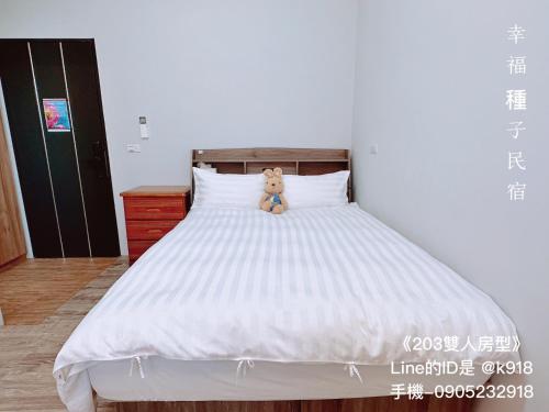un osito de peluche sentado encima de una cama en Sweet House en Xuejia