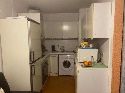 eine kleine Küche mit einem Kühlschrank und einer Waschmaschine in der Unterkunft APPARTEMENT MAS DSU TANIT in Antibes