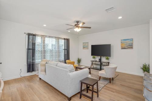 a living room with a couch and a tv at Chic Townhouse by LSU in Baton Rouge