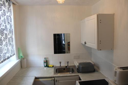 eine kleine Küche mit Spüle und Fenster in der Unterkunft Lawnswood Apartments in Blackpool