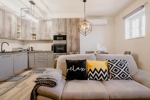 a living room with a couch and a kitchen at LA88 Bayview Rooms in Sliema
