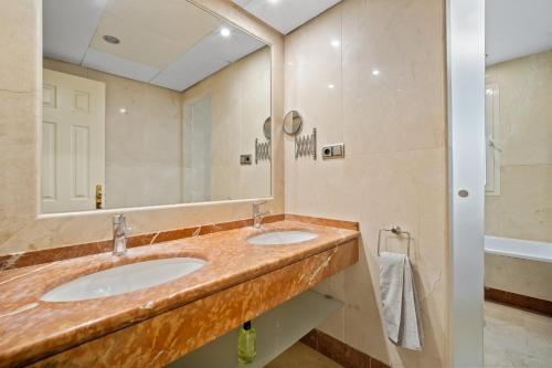 baño con 2 lavabos y espejo grande en Sierra Blanca, en Marbella