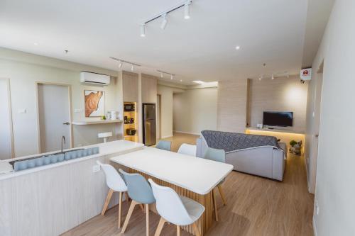 a kitchen and living room with a table and chairs at QUEENSLAND SUITES at Aru Suites, Kota Kinabalu in Kota Kinabalu