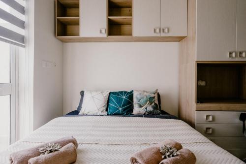 a small bedroom with a bed with two ottomans at LA88 Bayview Rooms in Sliema
