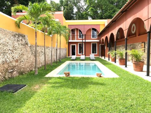 a swimming pool in the yard of a building at Hotel Hacienda Mérida in Mérida