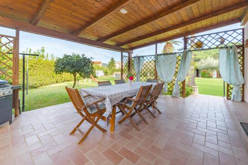 a dining room with a table and chairs on a patio at Albero del Pepe 2 - Goelba in Marina di Campo
