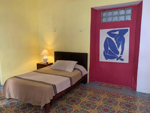 a bedroom with a bed and a red door at Casa "La 44" in Mérida