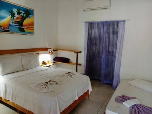- une chambre avec un lit blanc et une fenêtre dans l'établissement Gostoso Sol e Mar Pousada, à São Miguel do Gostoso