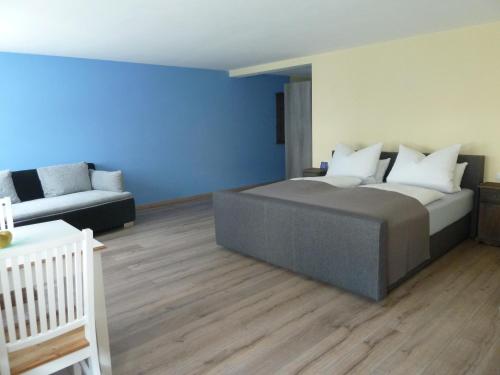 a bedroom with a large bed and a couch at Daschner GmbH in Waldmünchen