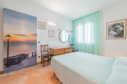 a bedroom with a bed and a desk and a table at L'Albero del Pepe 1 - Goelba in Campo nell'Elba