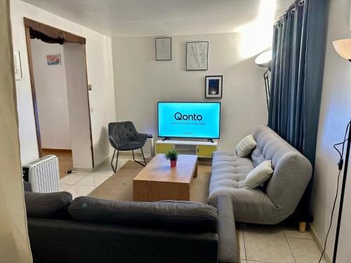 - un salon avec un canapé et une télévision dans l'établissement Aubervilliers maison de ville près métro 7 by immo kit bnb, à Aubervilliers