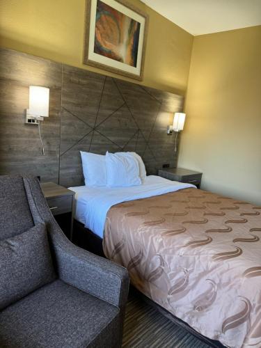 a hotel room with a bed and a couch at Quality Inn near I-72 and Hwy 51 in Forsyth
