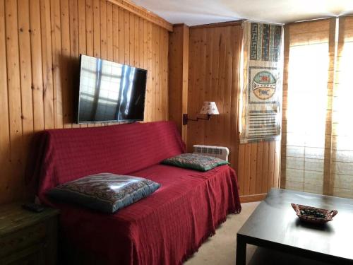 sala de estar con sofá rojo y mesa en Sierra Nevada Estudio Luminoso Urb Los Valles, en Monachil