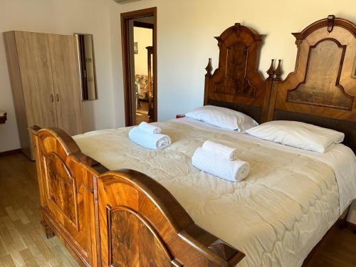 uma grande cama de madeira com duas toalhas em Appartamento in Franciacorta vicino al Lago Iseo em Corte Franca
