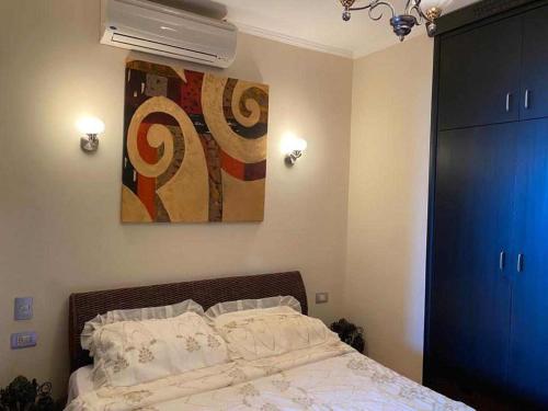 a bedroom with a bed and a painting on the wall at Porto marina for rent in El Alamein