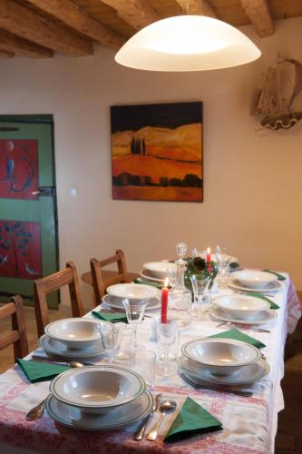a dining room table with plates and dishes on it at Maison traditionnelle briançonnaise in Briançon