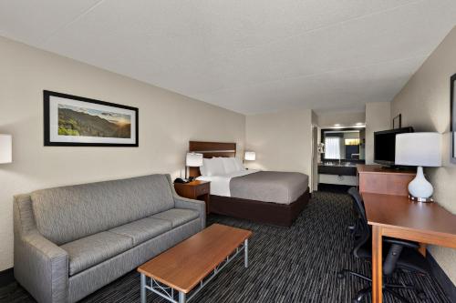 a hotel room with a bed and a couch and a desk at Quality Inn in Dandridge