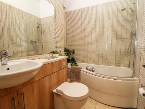 a bathroom with a sink and a toilet and a bath tub at The Arms House in Telford