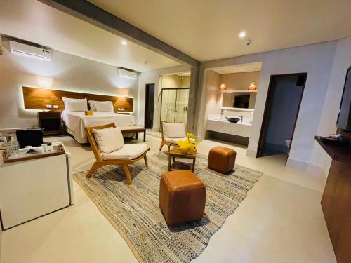 a hotel room with a bed and a living room at Hiu Hotel in Juquei