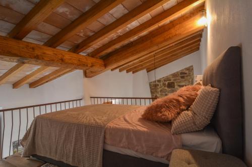 una camera con letto in una stanza con soffitti in legno di La Torretta a Collelungo