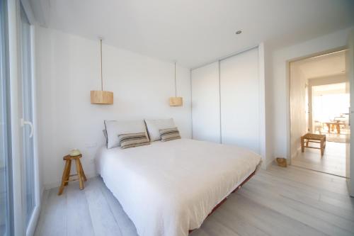 ein weißes Schlafzimmer mit einem weißen Bett und Kissen in der Unterkunft T3 Octopus VUE MER Palavas in Palavas-les-Flots