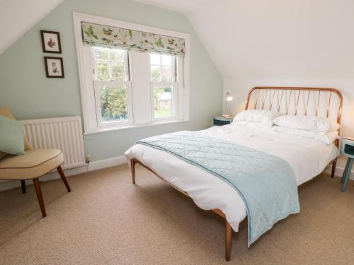a bedroom with a large bed and a window at 5 The Nab House in Bembridge