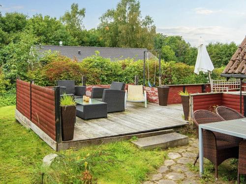 a backyard with a wooden deck with chairs and a table at 5 person holiday home in Allingåbro-By Traum in Allingåbro