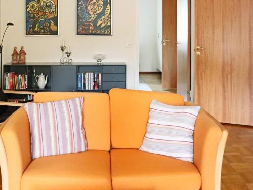 an orange couch with two striped pillows on it at 4 person holiday home in HYLTEBRUK-By Traum in Hyltebruk