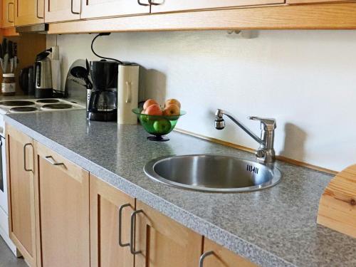 eine Küchentheke mit einer Spüle und einer Obstschale in der Unterkunft Holiday home HYLTEBRUK III in Hyltebruk