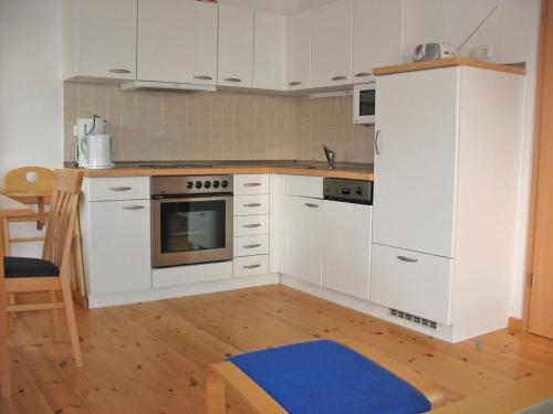 a kitchen with white appliances and a wooden floor at FLOATING HOUSES - "schwimmende Ferienhäuser" - Haus 5 in Barth