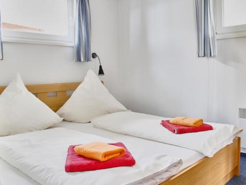 two beds in a room with red and white towels at FLOATING HOUSES - "schwimmende Ferienhäuser" - Haus 5 in Barth