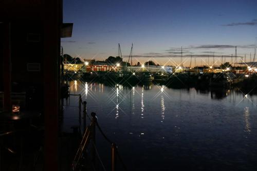 a marina at night with boats in the water at FLOATING HOUSES - "schwimmende Ferienhäuser" - Haus 2 in Kröslin