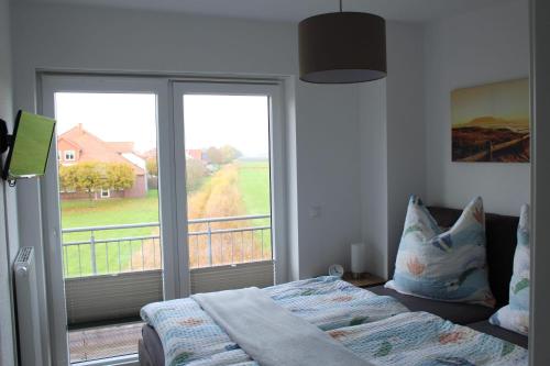 a bedroom with a bed and a balcony with a window at Ferienhaus Traummomente in Stick