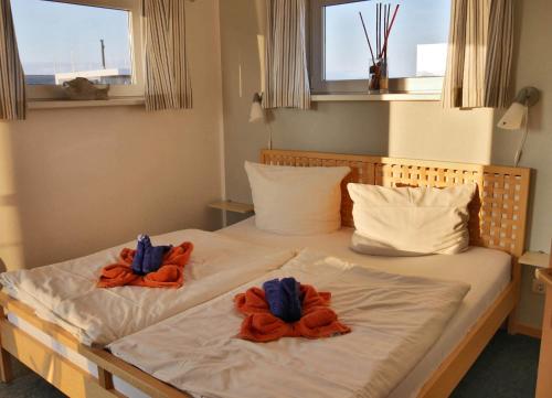 two towels are sitting on top of a bed at FLOATING HOUSES - "schwimmende Ferienhäuser" - Haus 3 in Kröslin