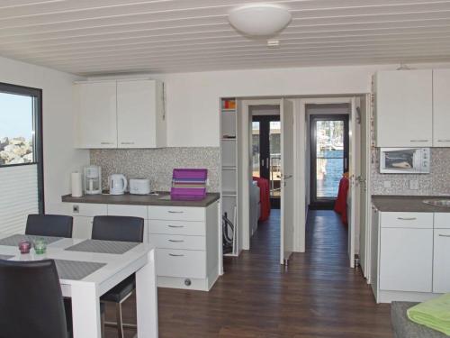 eine Küche mit weißen Schränken und einer Arbeitsplatte in der Unterkunft Hausboot Floating 44 in Laboe - Boot 2 in Laboe