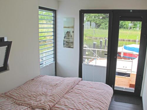 ein Schlafzimmer mit einem Bett und ein Fenster mit einem Boot in der Unterkunft Hausboot - FLOATING 44 in Ueckermünde in Ueckermünde