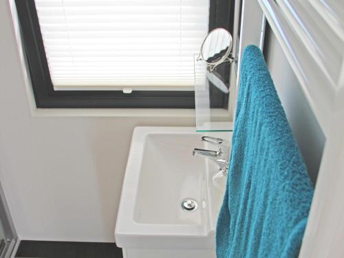 ein Badezimmer mit einem Waschbecken und einem blauen Handtuch in der Unterkunft Hausboot - FLOATING 44 in Ueckermünde in Ueckermünde