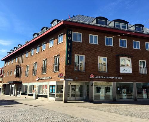a large red brick building on a street at Hotell Siesta in Karlskrona