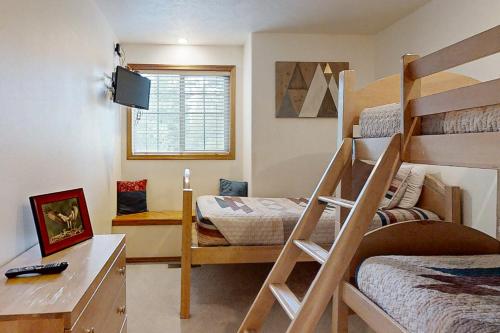 a small room with two bunk beds and a desk at 12 Whistler in Sunriver