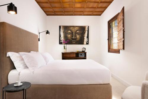 a bedroom with a white bed and a painting on the wall at Torre delle Cornacchie in Rome