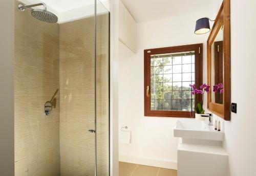 un bagno con doccia in vetro e lavandino di Torre delle Cornacchie - Private Pool Villa a Roma