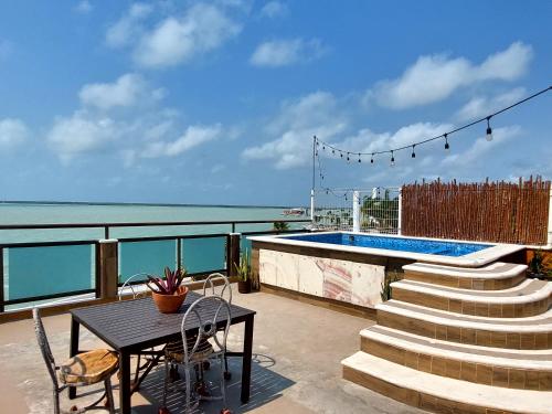 uma mesa e cadeiras numa varanda com vista para o oceano em Hotel "ala Residencias" em Chetumal