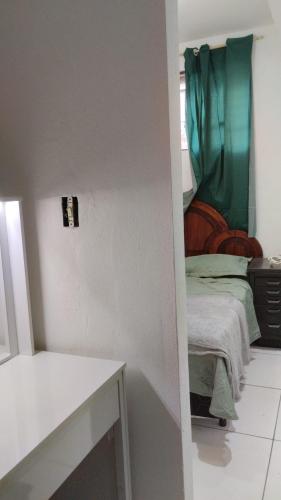 ein Schlafzimmer mit einem Bett mit einem grünen Vorhang in der Unterkunft HC V Nova in Belo Horizonte