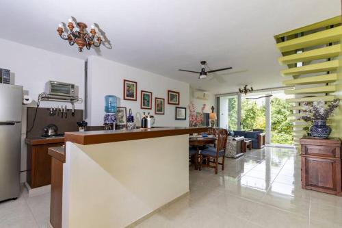 a kitchen with a counter and a dining room at Casa Laak Fabulous rustic townhouse in Mérida