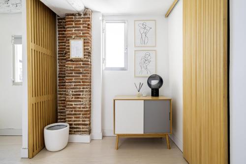 una camera con un armadietto bianco e un muro di mattoni di apartamento el barrio de lavapies a Madrid