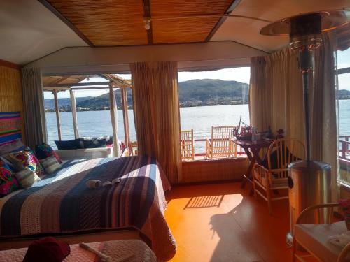 a bedroom with a bed and a view of the water at TITICACA DELUXE LODGE in Puno