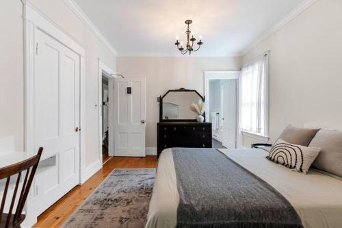 biała sypialnia z łóżkiem i lustrem w obiekcie Studio 7 ~ 1 BDRM w/ Private Bath & Living Room w mieście Moncton