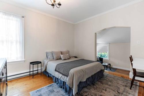 um quarto branco com uma cama e um espelho em Studio 7 ~ 1 BDRM w/ Private Bath & Living Room em Moncton